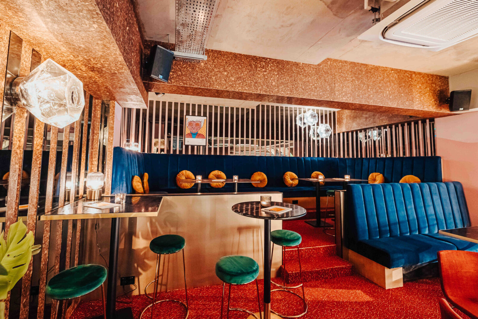 Blue velvet booths and green bar stools at Someday, Finsbury Park
